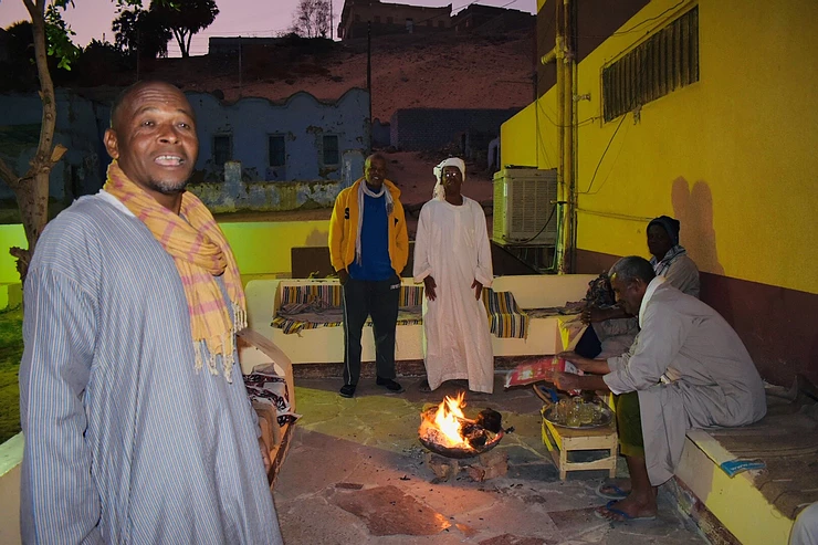 Men congregating round the fire on the verandah in the Nubian Village