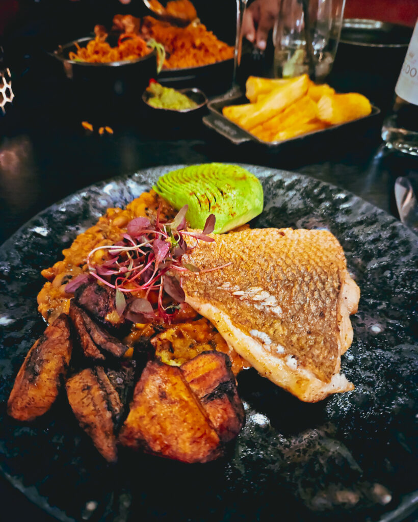 Stork Restaurant - Shallow Fried Red Snapper - Classic red red stew, plantain, tomato confit, black eyed beans and finished with avocado