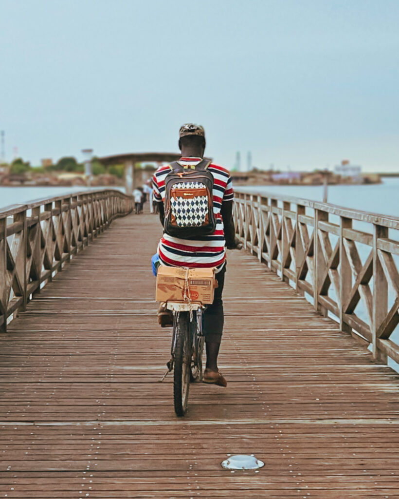 Man riding over bridge from Joal to Fadiouth